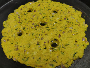 Holes made and oil added in the thalipeeth